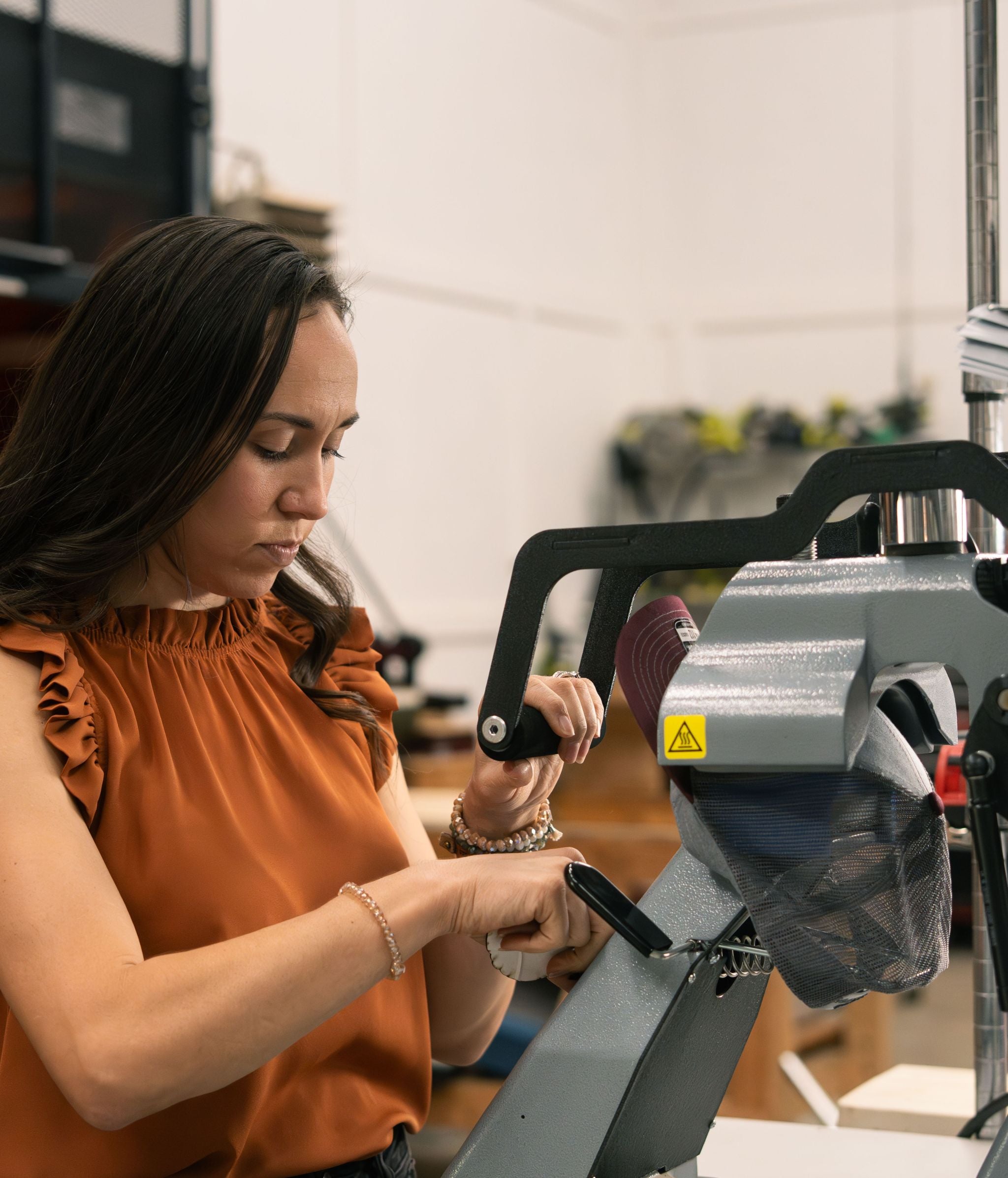 Woman working on a hat press